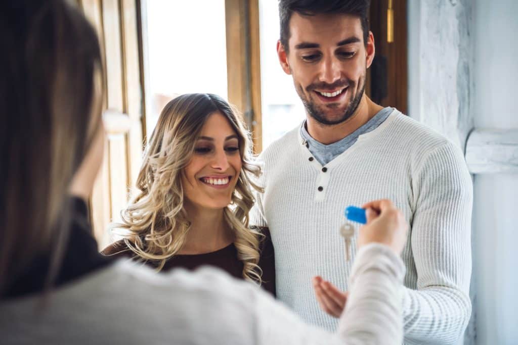 Couple handed keys by real estate broker